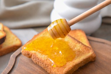 Tatlı bal masadaki kızarmış ekmeğe damlıyor.