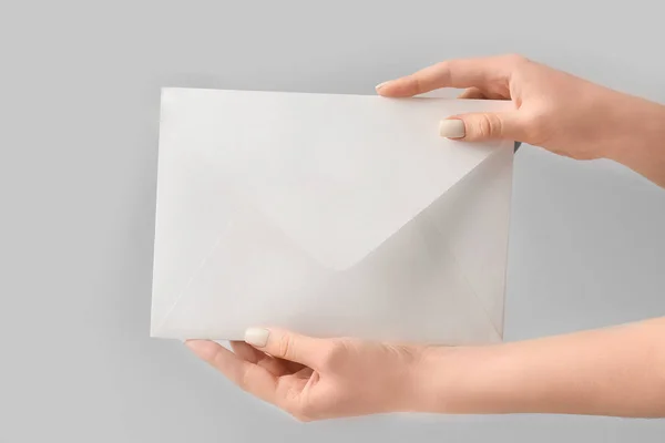 Female hands with envelope on grey background — Stock Photo, Image