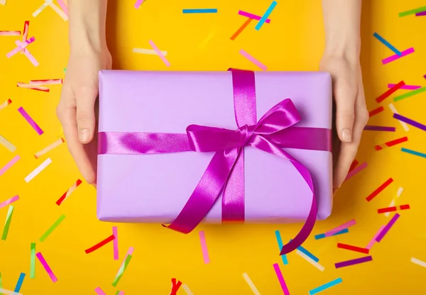 Manos femeninas con hermosa caja de regalo sobre fondo de color — Foto de Stock