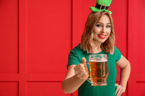 Belle jeune femme avec de la bière sur fond de couleur. Célébration de la Saint Patrick — Photo