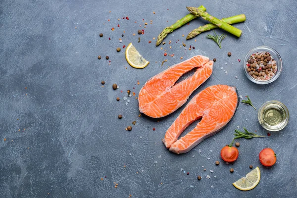 Raw salmon steaks and spices on dark background — Stock Photo, Image