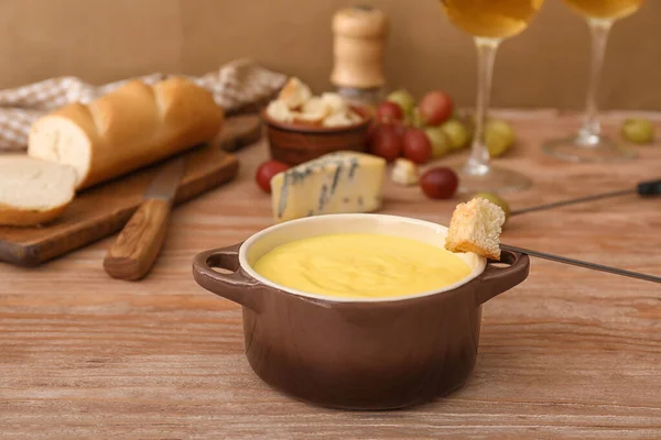 Mergulho de crouton em fondue de queijo na mesa — Fotografia de Stock