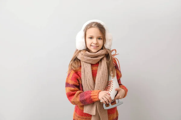 Petite fille mignonne avec des patins à glace sur fond clair — Photo