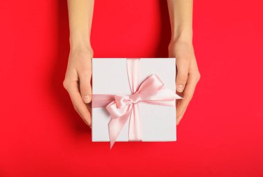 Renkli arka planda güzel hediye kutusu ile Kadın eller