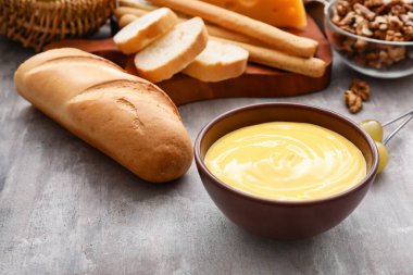 Gri arkaplanlı peynirli fondü.