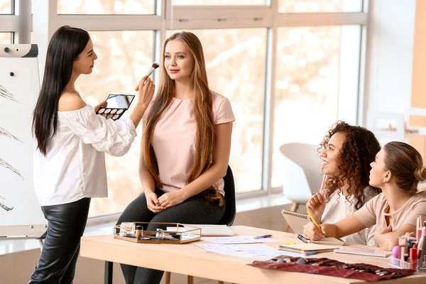 Young woman teaching students in makeup school — Stock Photo, Image