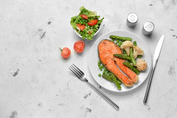 stock image Tasty fried salmon with vegetables and salad on table