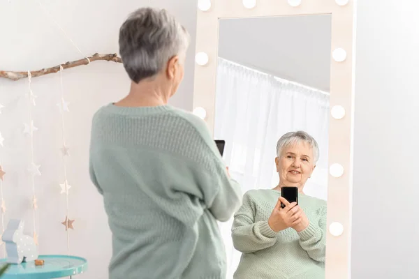 Feliz mujer mayor tomando selfie delante del espejo en casa — Foto de Stock