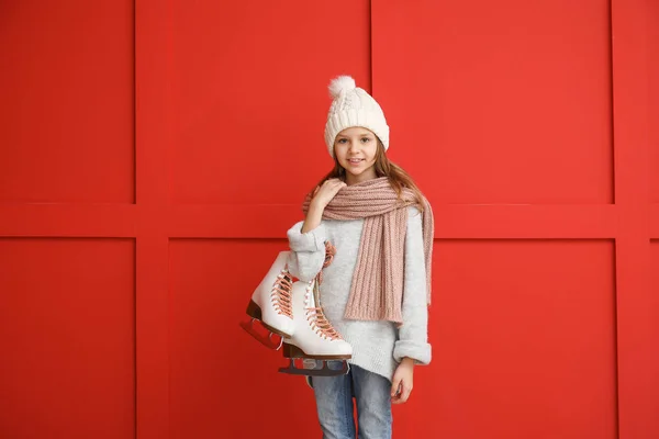 Menina bonito com patins de gelo no fundo de cor — Fotografia de Stock