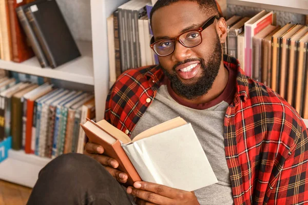 Estudiante afroamericano leyendo libro mientras se prepara para el examen en la biblioteca — Foto de Stock