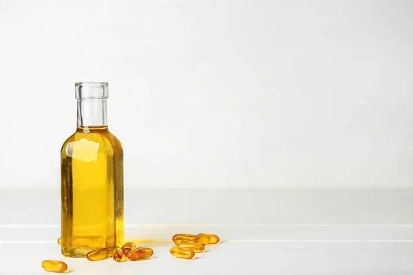 Bottle of fish oil and pills on white background — Stock Photo, Image
