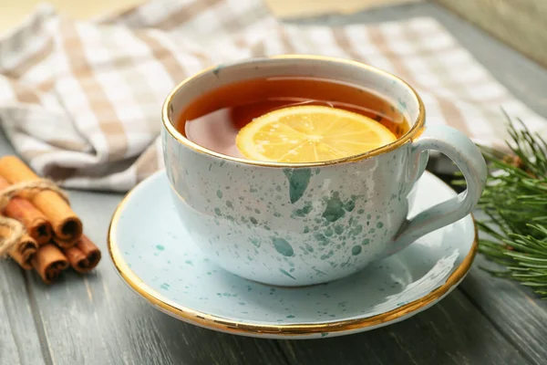 Cup of hot tea with lemon and cinnamon on table — Stock Photo, Image
