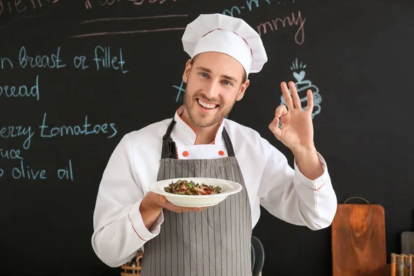 Щасливий чоловічий шеф-кухар з готовою стравою на кухні — стокове фото