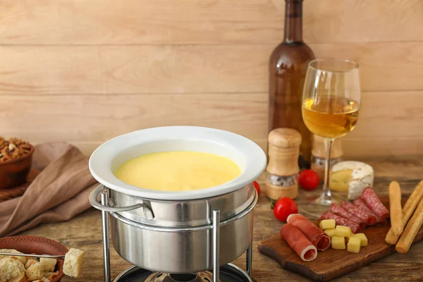 Fondue de queso con aperitivos y vino en la mesa —  Fotos de Stock