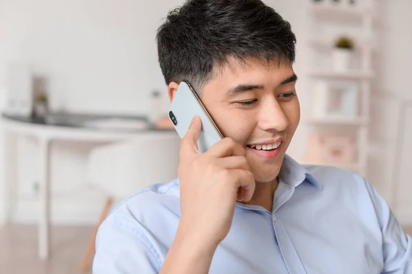 Jovem empresário asiático falando por telefone no escritório — Fotografia de Stock