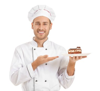 Beyaz arka planda kek dilimi olan mutlu erkek aşçı.