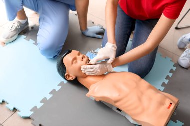 CPR ilk yardım eğitim kursu, manken üzerinde gösteren eğitmen