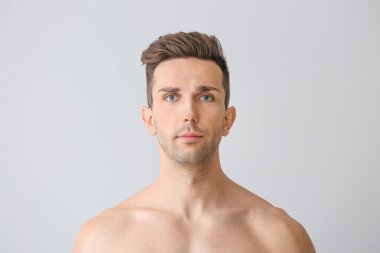 Hafif arka planda yakışıklı bir genç adam. Estetik ameliyat konsepti