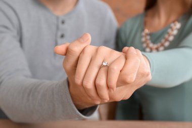 Mutlu nişanlı genç çiftin elleri, yakın plan.