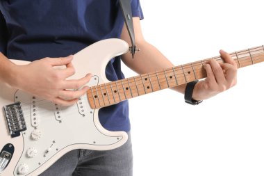 Genç adam beyaz arka planda gitar çalıyor.