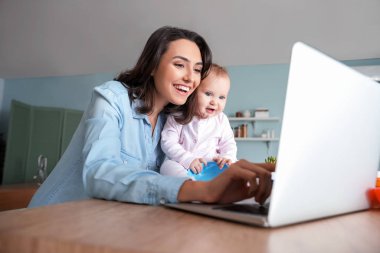 Evde bebeğiyle çalışan bir anne.