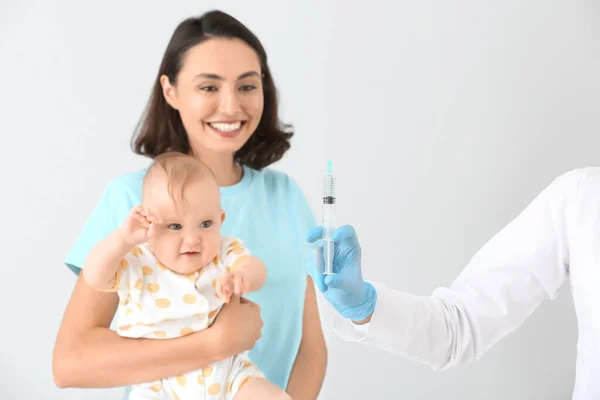 Pediatriker vaccinera lilla barnet på ljus bakgrund — Stockfoto