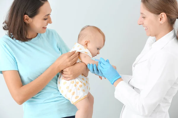 儿科医生在浅色背景下给小宝宝接种疫苗 — 图库照片