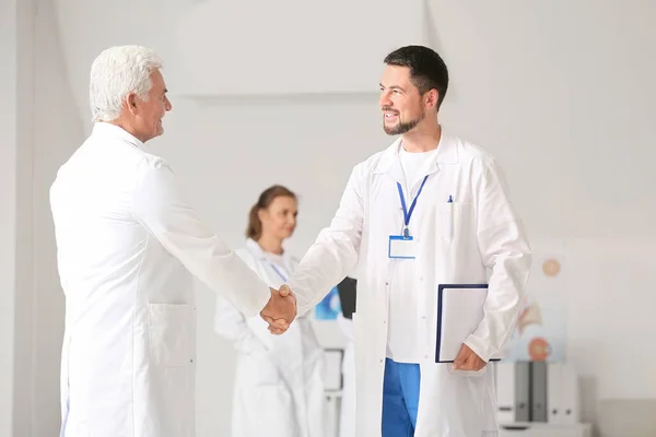 Профессиональные врачи-мужчины пожимают руки в клинике — стоковое фото