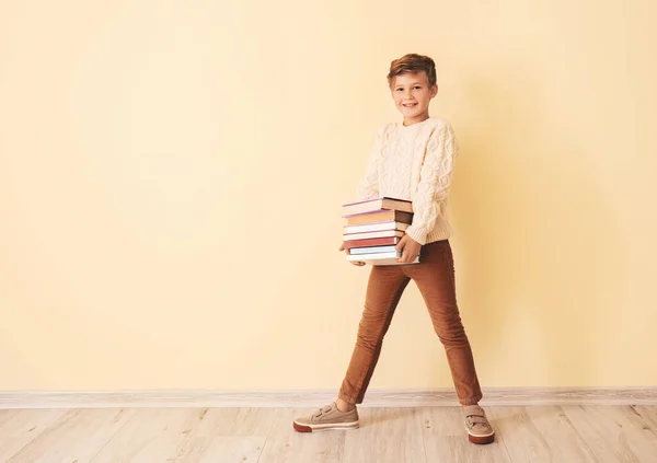 Kleiner Junge mit Büchern nahe der Farbwand — Stockfoto
