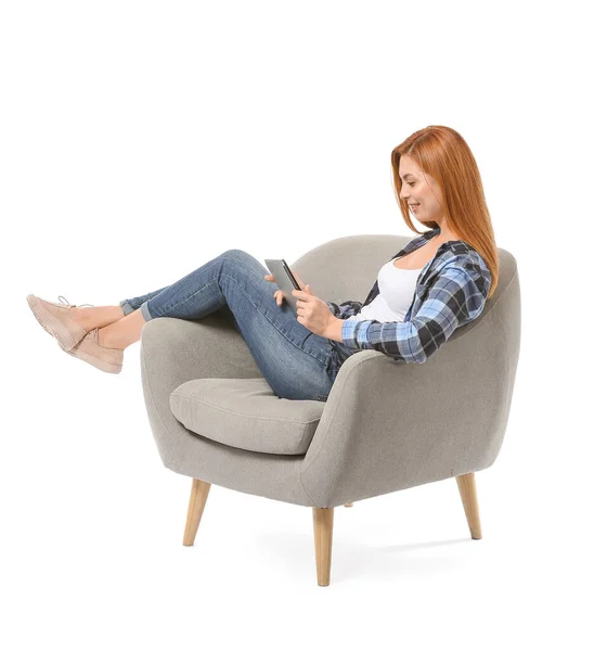 Beautiful woman with tablet computer sitting in armchair against white background — Stock Photo, Image