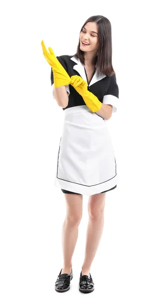 Retrato de bela camareira colocando luvas de borracha contra fundo branco — Fotografia de Stock