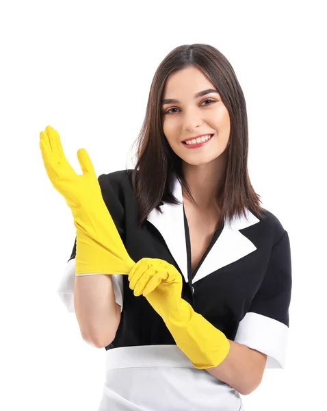 Retrato de la hermosa camarera poniéndose guantes de goma sobre fondo blanco — Foto de Stock