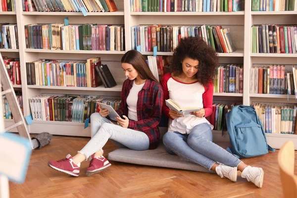 Jóvenes estudiantes preparándose para el examen en la biblioteca — Foto de Stock