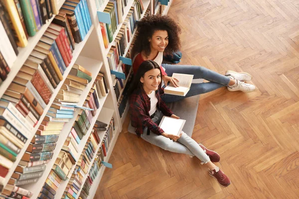 Jóvenes estudiantes preparándose para el examen en la biblioteca — Foto de Stock