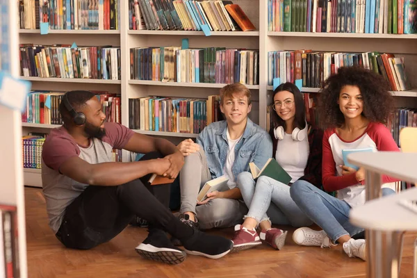 Jóvenes estudiantes preparándose para el examen en la biblioteca — Foto de Stock