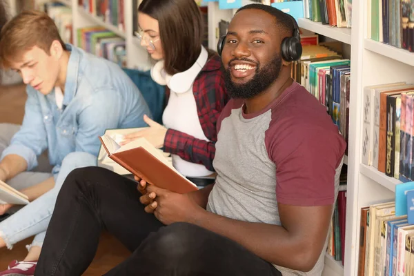 African-American student with friends preparing for exam in library — Stock Photo, Image