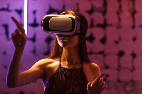 Modische junge Frau mit Virtual-Reality-Brille auf dunklem Hintergrund — Stockfoto