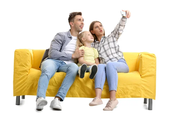 Happy young family taking selfie on sofa against white background — Stock Photo, Image