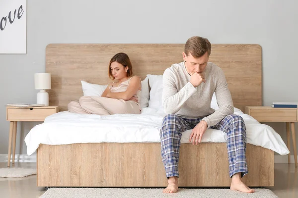 Sad couple after quarrel in bedroom