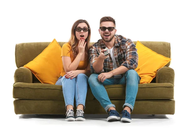 Pareja joven viendo la televisión mientras está sentada en un sofá sobre fondo blanco — Foto de Stock