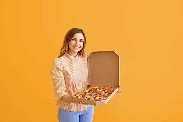 Portrait of beautiful young woman with tasty pizza on color background — Stock Photo, Image