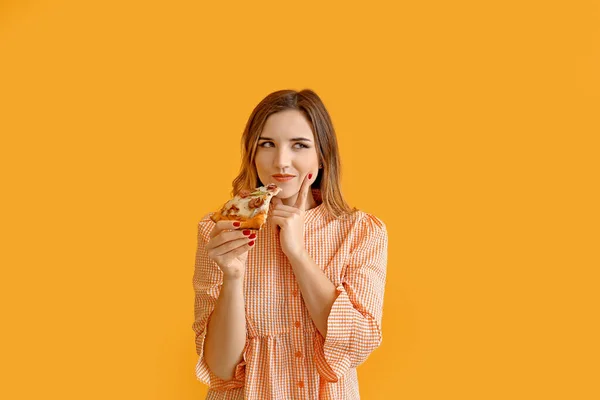 Ritratto di bella giovane donna che mangia pizza su sfondo a colori — Foto Stock