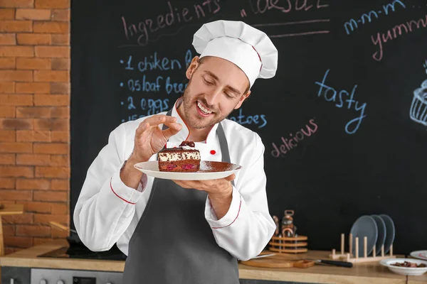 Мужской шеф-повар с кусочком торта на кухне — стоковое фото