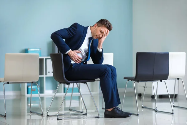 Jeune homme d'affaires souffrant de douleurs abdominales au bureau — Photo