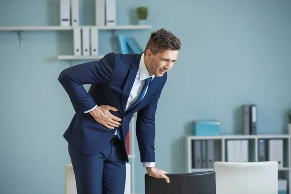 Young businessman suffering from abdominal pain in office — Stock Photo, Image