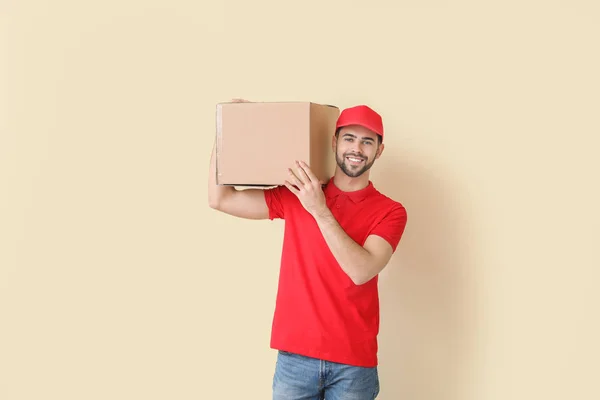Entrega homem com caixa no fundo de cor — Fotografia de Stock