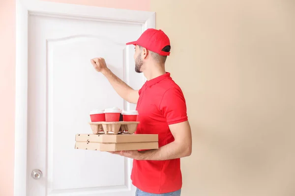 Bonito trabalhador do serviço de entrega de alimentos batendo na porta — Fotografia de Stock