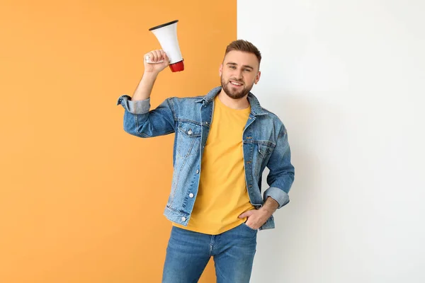 Jovem emocional com megafone sobre fundo de cor — Fotografia de Stock