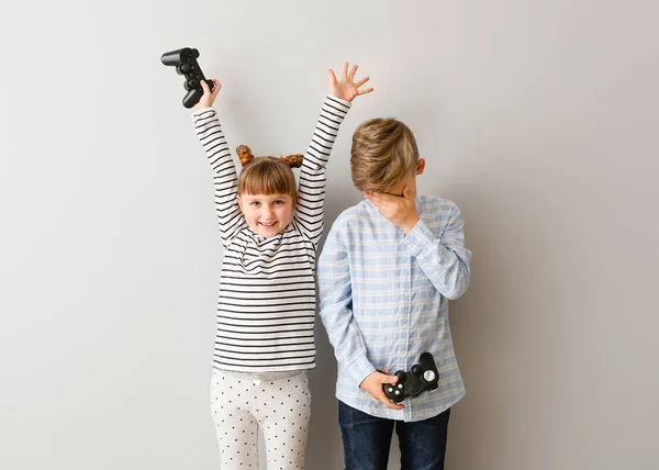 Bambini piccoli che giocano ai videogiochi su sfondo grigio — Foto Stock