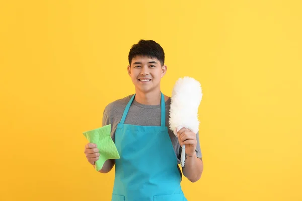 Ásia homem com limpeza suprimentos no cor fundo — Fotografia de Stock